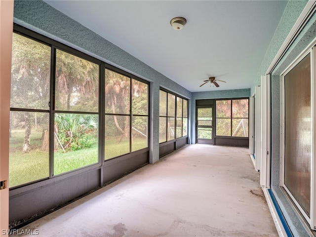 unfurnished sunroom with a wealth of natural light and ceiling fan