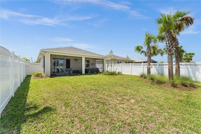 rear view of house featuring a sunroom and a lawn