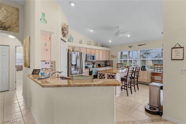 kitchen with sink, tasteful backsplash, light brown cabinetry, appliances with stainless steel finishes, and kitchen peninsula