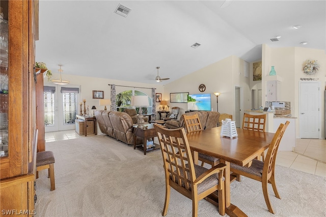 dining space with ceiling fan, french doors, light colored carpet, and vaulted ceiling