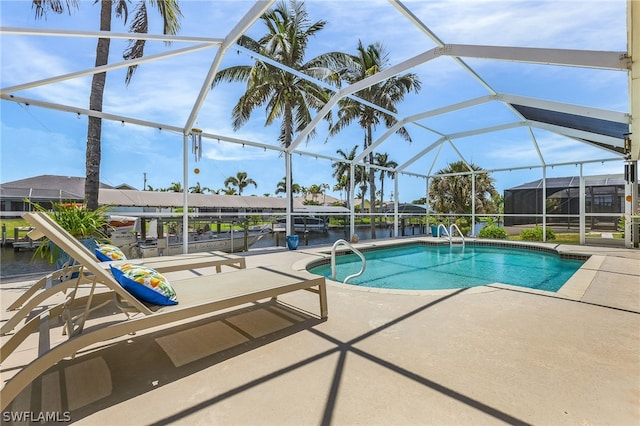 view of pool with a lanai, a water view, and a patio