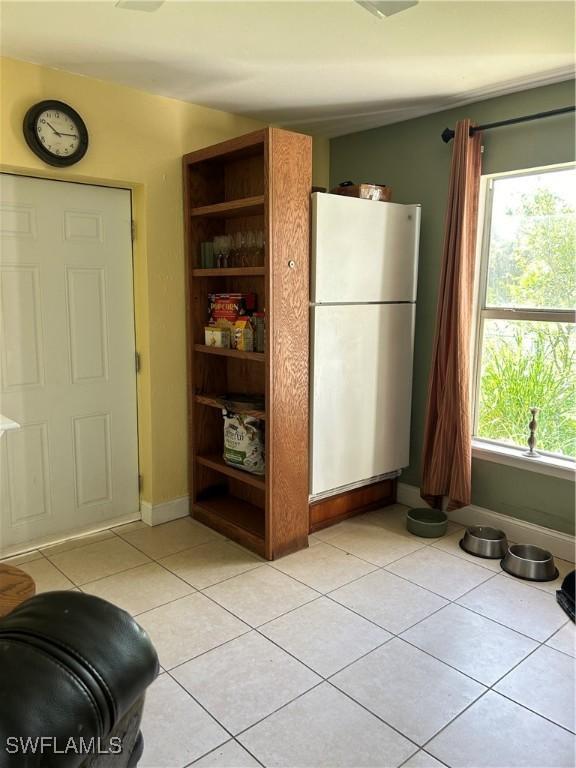 4720 22nd Ave SE, Naples, FL 34117 - kitchen featuring freestanding refrigerator, open shelves, light tile patterned floors, and healthy amount of natural light