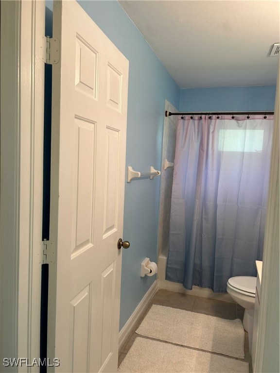 bathroom featuring shower / tub combo with curtain and toilet