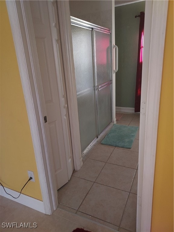 bathroom with tile patterned flooring and a shower with shower door