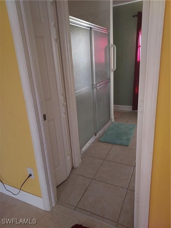 4720 22nd Ave SE, Naples, FL 34117 - bathroom with tile patterned flooring, a stall shower, and baseboards