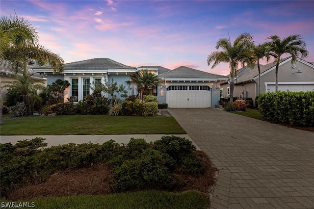 single story home featuring a yard and a garage