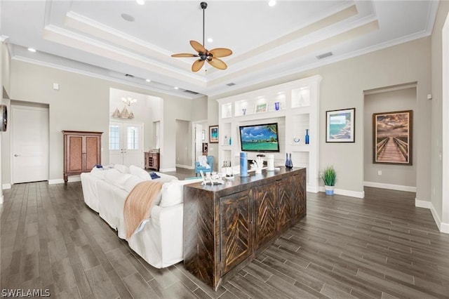 living room featuring ceiling fan, a raised ceiling, and ornamental molding