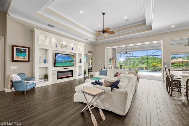 living room with crown molding and a tray ceiling