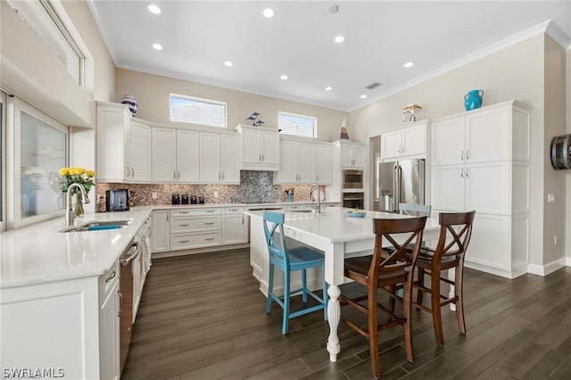 kitchen featuring a kitchen breakfast bar, an island with sink, stainless steel appliances, and sink