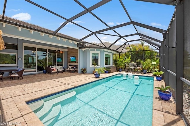 view of swimming pool featuring ceiling fan, a patio area, and a lanai