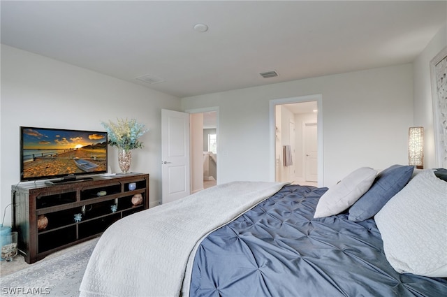 bedroom featuring ensuite bathroom and light colored carpet