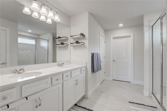 bathroom with tile patterned flooring, vanity, and a shower with door