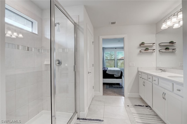 bathroom featuring tile patterned flooring, vanity, and a shower with door