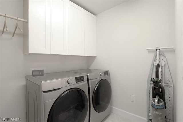 laundry room with washer and dryer and cabinets