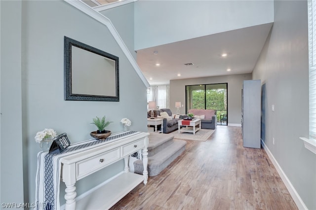 hallway featuring light wood-type flooring and ornamental molding