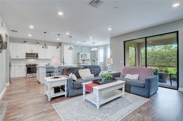 living room featuring a chandelier and light hardwood / wood-style floors