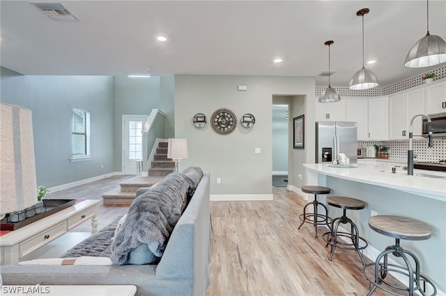 kitchen with stainless steel appliances, tasteful backsplash, pendant lighting, a breakfast bar area, and white cabinets