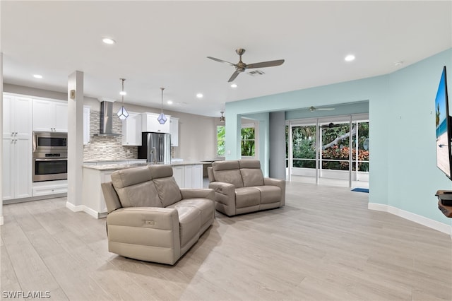 living room featuring ceiling fan and light hardwood / wood-style flooring