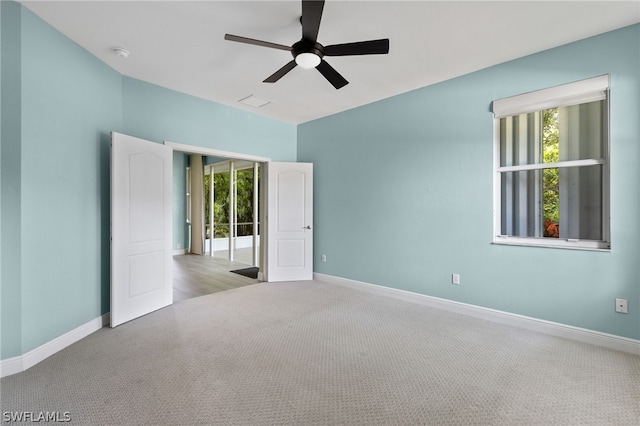 carpeted spare room with ceiling fan