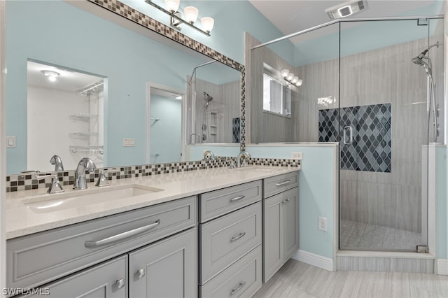 bathroom with vanity, decorative backsplash, and a shower with shower door