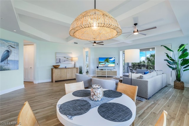 dining space featuring ceiling fan, beamed ceiling, and wood-type flooring