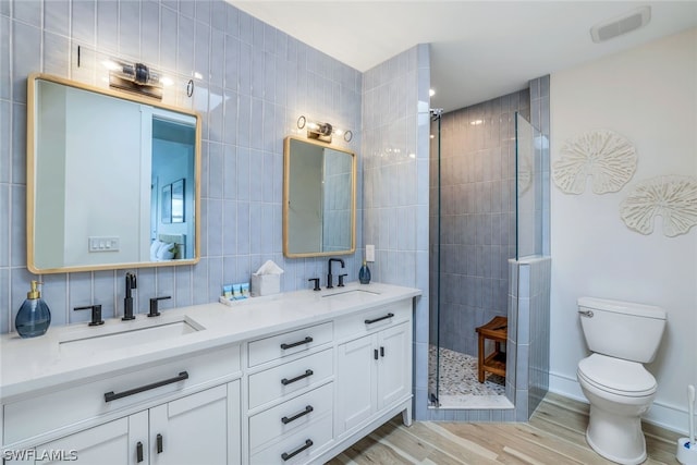 bathroom featuring vanity, a shower, backsplash, toilet, and wood-type flooring