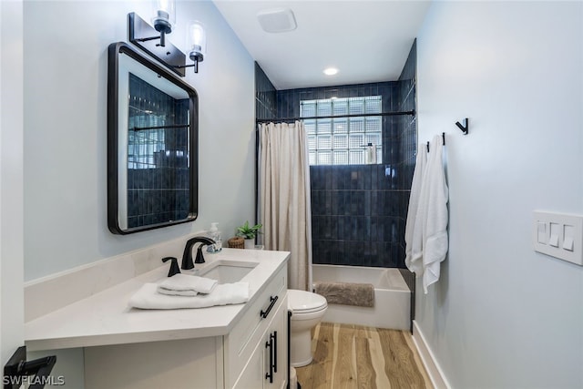 full bathroom featuring hardwood / wood-style floors, vanity, toilet, and shower / tub combo