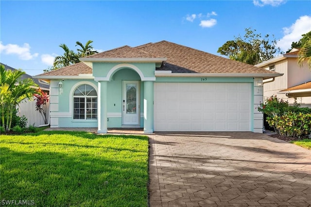 view of front of house with a garage and a front lawn