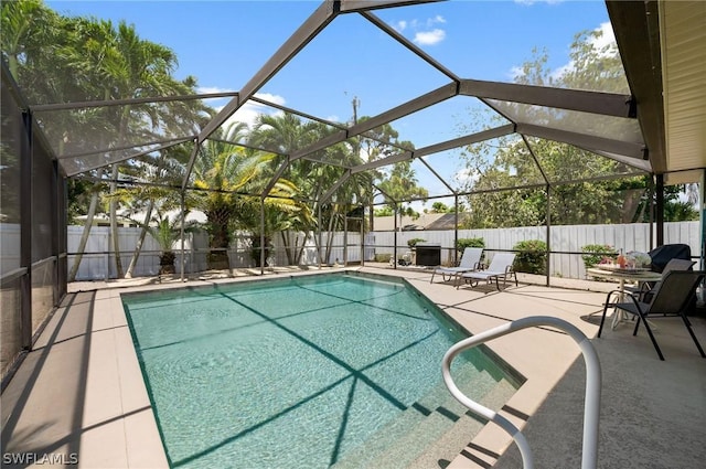 view of swimming pool with glass enclosure and a patio area