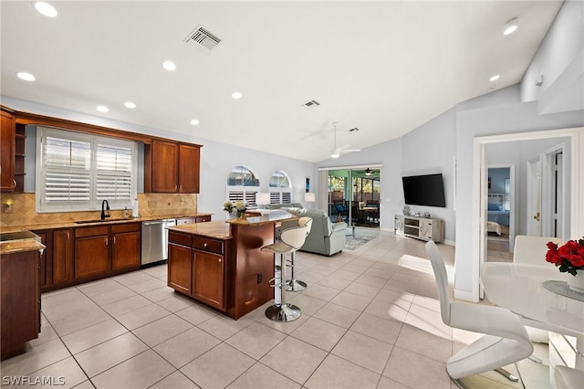 kitchen with dishwasher, a center island, vaulted ceiling, and sink