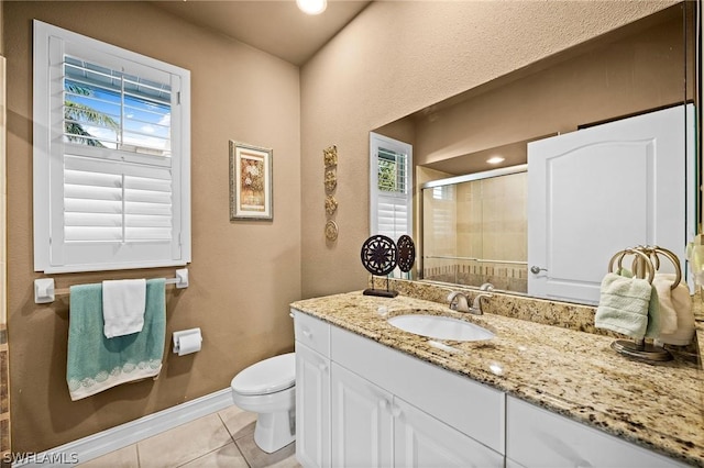 bathroom with tile patterned flooring, vanity, toilet, and a shower with shower door