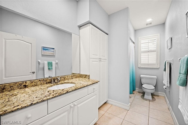 bathroom featuring tile patterned flooring, vanity, and toilet