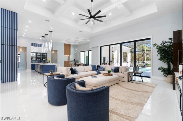 living room with ceiling fan, beam ceiling, a high ceiling, and coffered ceiling