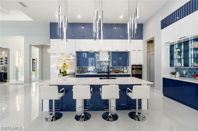 kitchen with sink, decorative light fixtures, stainless steel appliances, and a kitchen bar