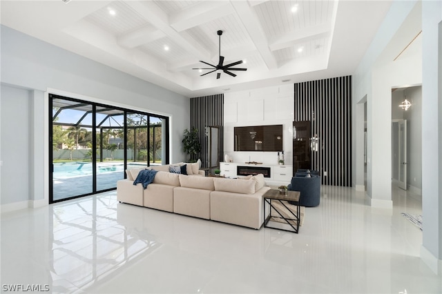 living room with beamed ceiling, ceiling fan, coffered ceiling, and a high ceiling