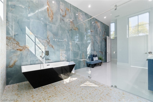 bathroom with a bathing tub and tile walls