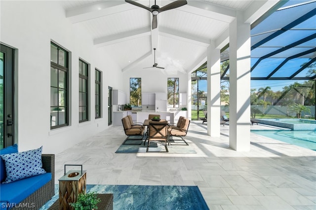 view of patio / terrace with exterior kitchen, an outdoor hangout area, ceiling fan, and glass enclosure