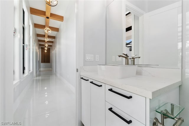 bathroom with vanity and beam ceiling