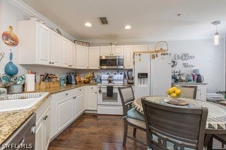 kitchen featuring dark hardwood / wood-style floors, stainless steel appliances, pendant lighting, light stone counters, and white cabinetry