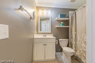 bathroom with ornamental molding, tile flooring, toilet, and vanity