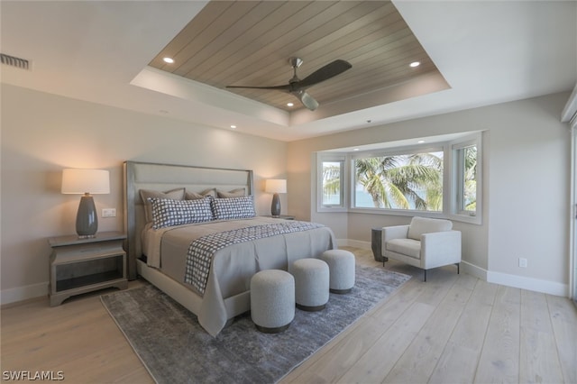 bedroom with ceiling fan, light hardwood / wood-style floors, a raised ceiling, and wood ceiling