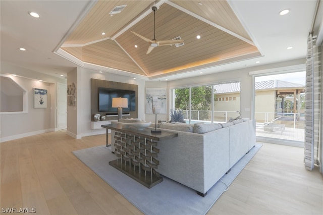 living room with a tray ceiling, wood ceiling, light wood-type flooring, and ceiling fan