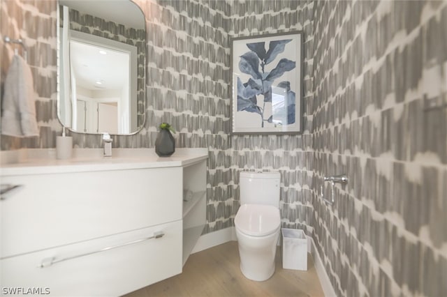 bathroom with wood-type flooring, vanity, toilet, and tile walls