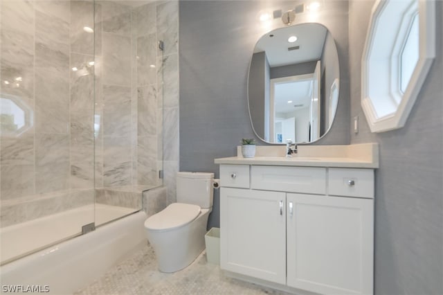 full bathroom with tile flooring, combined bath / shower with glass door, vanity, and toilet