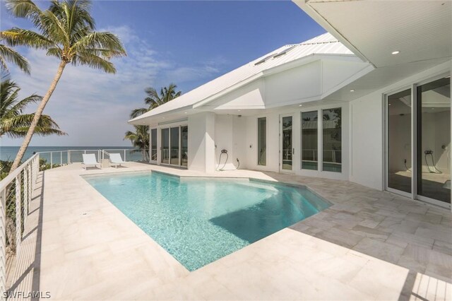 view of pool featuring a water view and a patio area