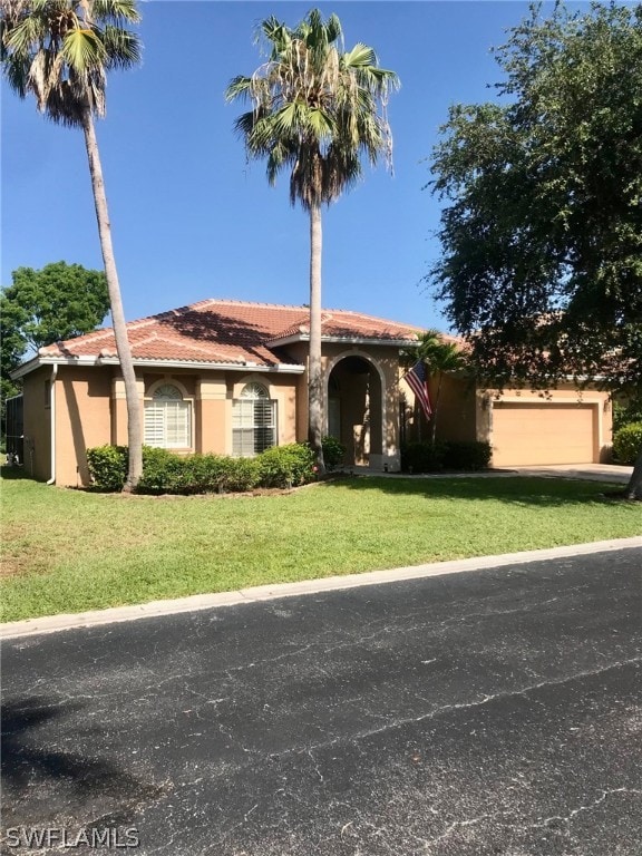 view of front of home with a front lawn and a garage