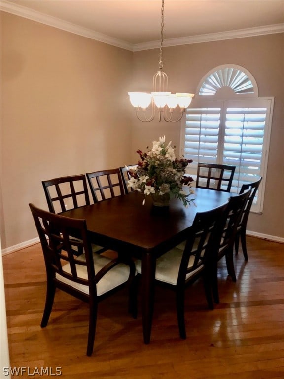 dining space featuring an inviting chandelier, hardwood / wood-style flooring, and ornamental molding