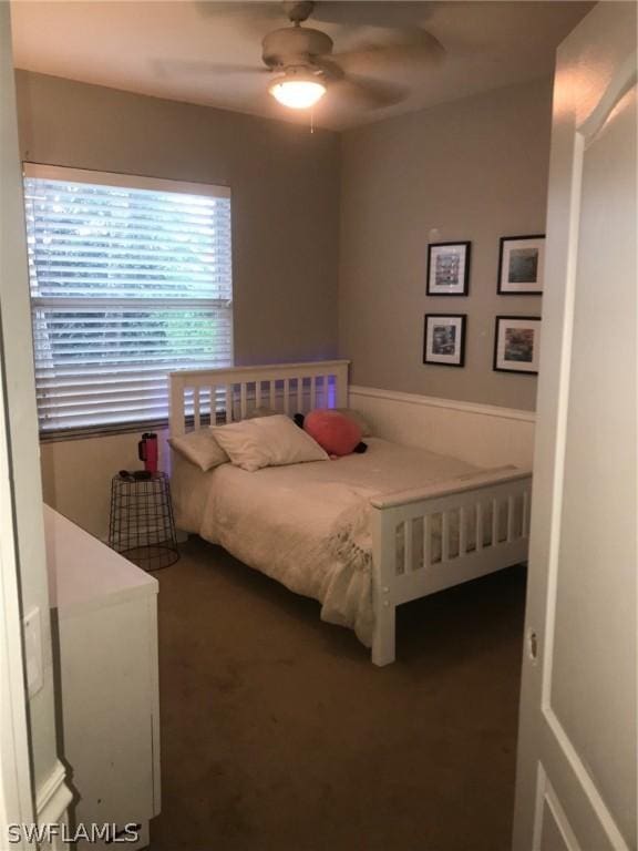 bedroom with dark colored carpet and ceiling fan