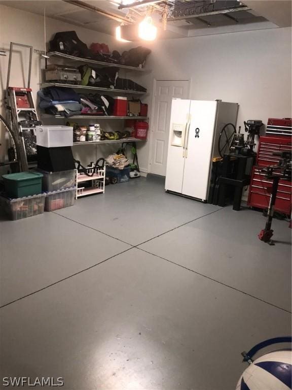 garage featuring white fridge with ice dispenser