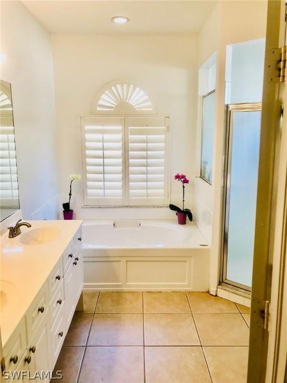 bathroom featuring independent shower and bath, vanity, and tile patterned floors